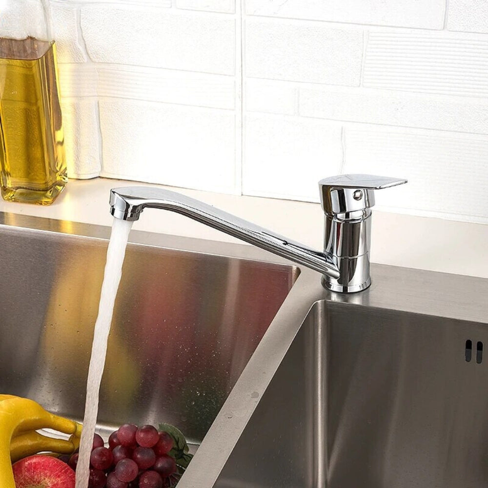Mitigeur de cuisine chromé à bec bas, eau qui coule dans un évier inox