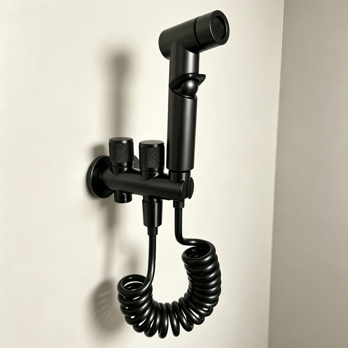 Douchette WC fixée au mur avec son té à deux commandes et son flexible spiralé